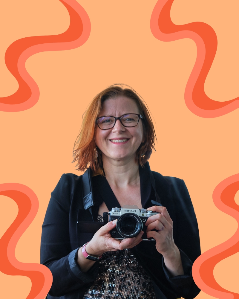 Familien- und Hochzeitsfotografin in Worms: Fotografin hält ihr Kamera auf Brusthöhe und lächelt